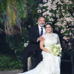 Pareja de novios madura posando elegantemente en un jardín para reportaje de video de boda en Mesa AZ.